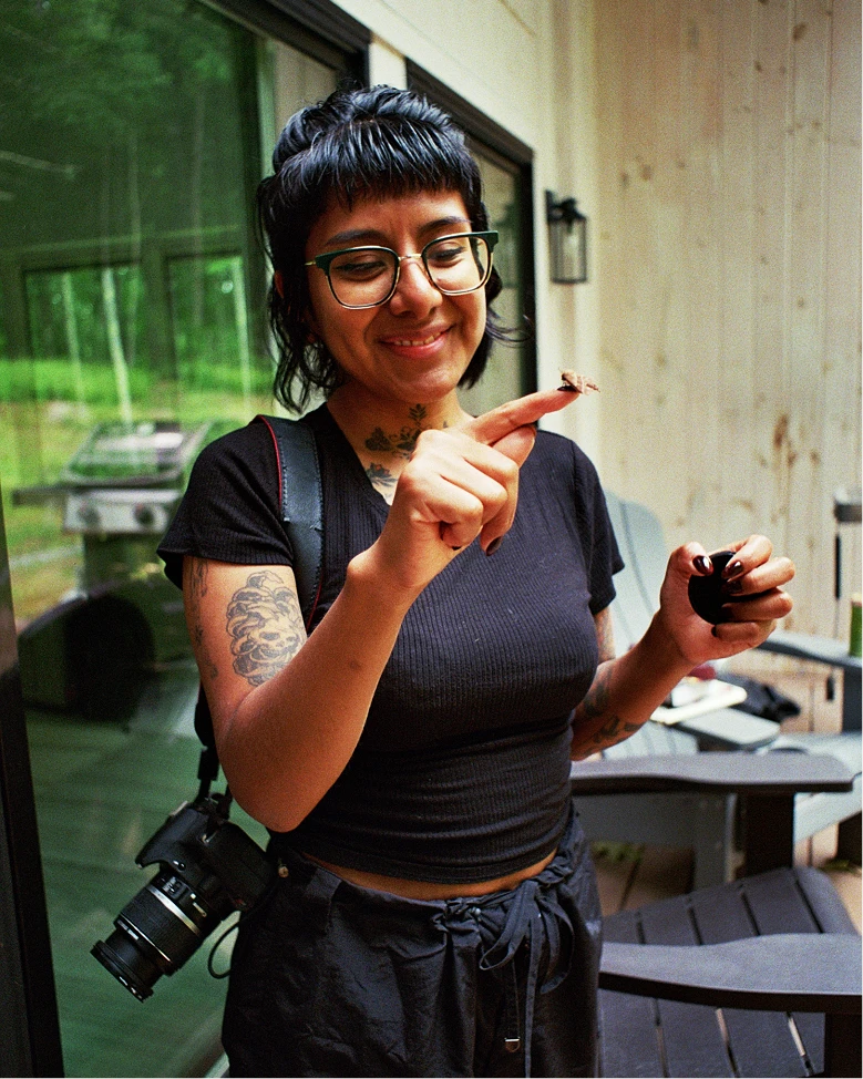 Yesenia Garcia smiling and holding a tiny miniature on her fingertip